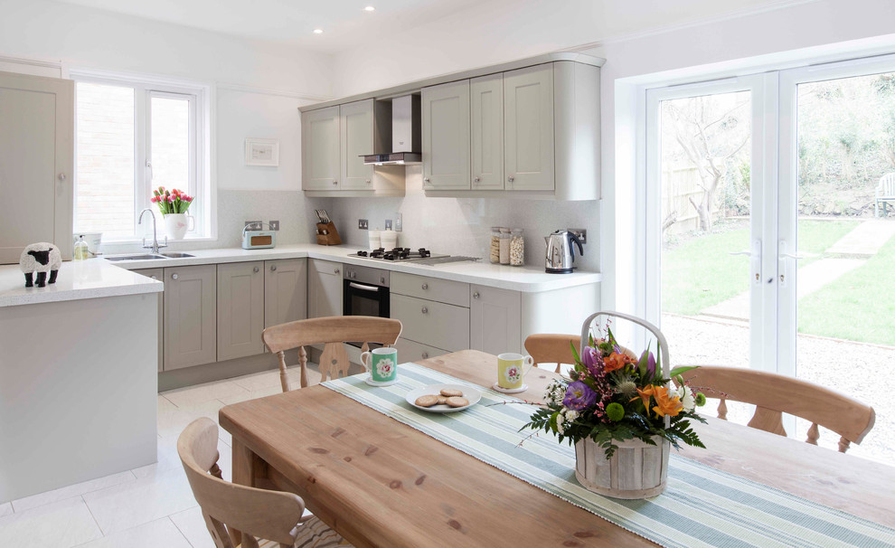 Inspiration for a medium sized traditional u-shaped kitchen/diner in Kent with recessed-panel cabinets, grey cabinets, recycled glass countertops and white splashback.