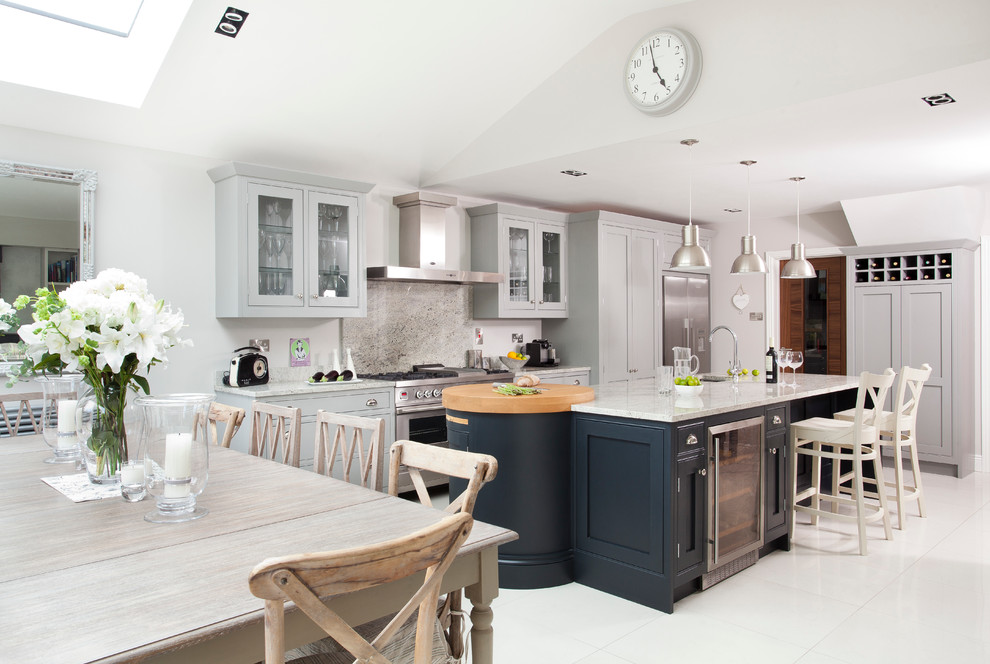 This is an example of a large contemporary l-shaped eat-in kitchen in Dublin with a single-bowl sink, shaker cabinets, grey cabinets, granite benchtops, grey splashback, stone slab splashback, stainless steel appliances, porcelain floors and with island.