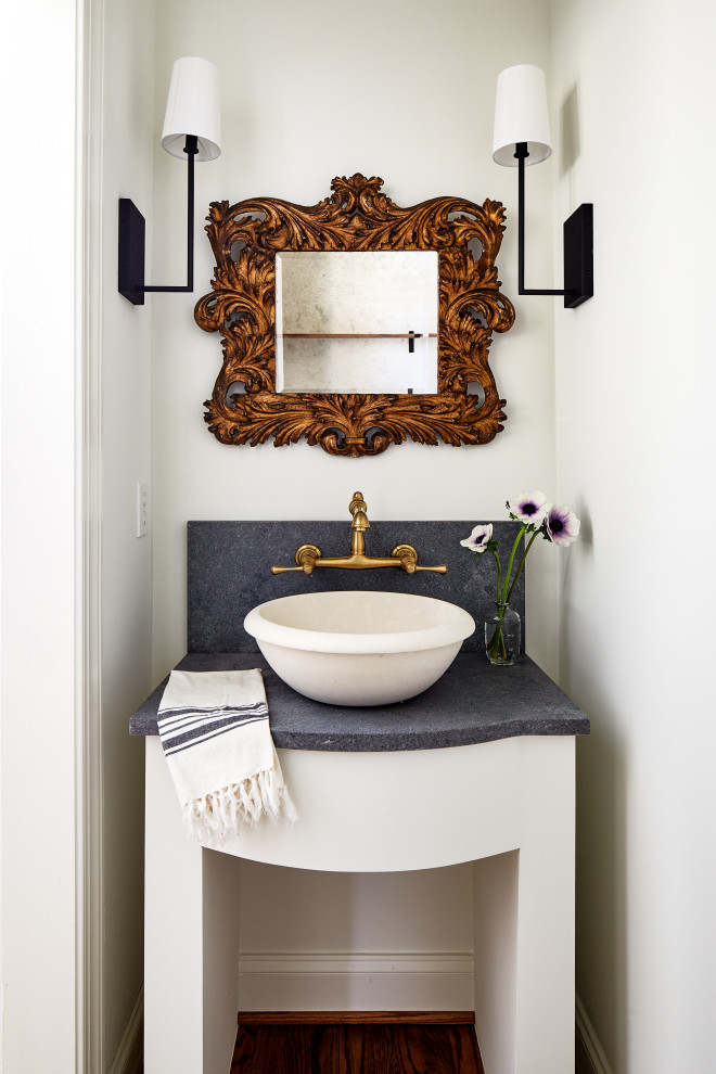 Photo of a small transitional powder room in DC Metro with white cabinets, white walls, medium hardwood floors, a vessel sink, granite benchtops, brown floor, black benchtops and a freestanding vanity.