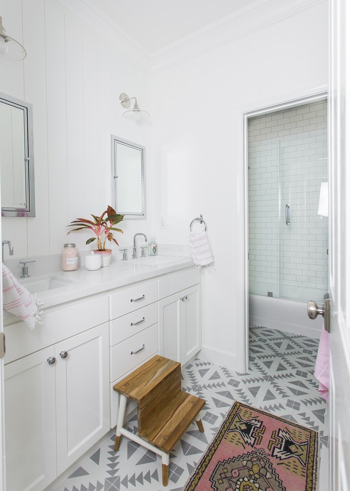 Photo of a transitional kids bathroom in Sacramento with shaker cabinets, white cabinets, an alcove shower, white walls, grey floor, a hinged shower door and white benchtops.