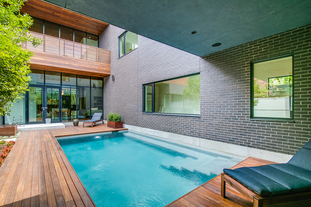 Small modern courtyard rectangular pool in Houston with decking.