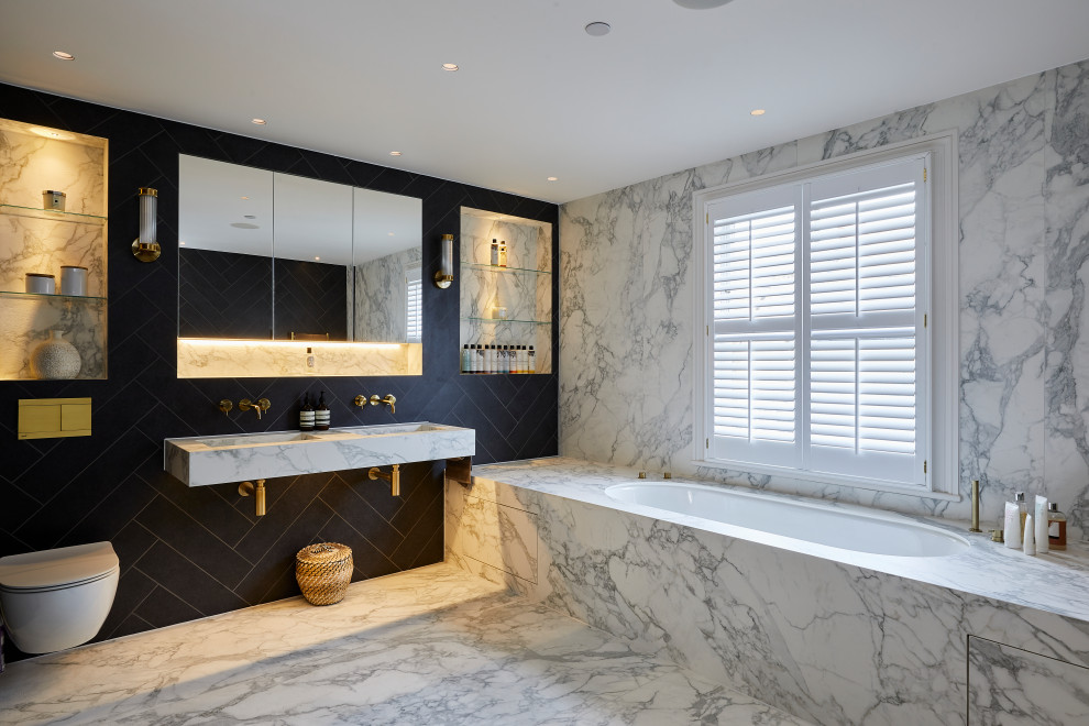 Modern inredning av ett stort en-suite badrum, med ett platsbyggt badkar, en vägghängd toalettstol, blå kakel, ett väggmonterat handfat och marmorbänkskiva