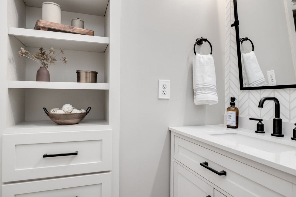 Mid-sized transitional powder room in Other with shaker cabinets, white cabinets, a one-piece toilet, beige walls, vinyl floors, an undermount sink, engineered quartz benchtops, beige floor, white benchtops, a freestanding vanity and wallpaper.