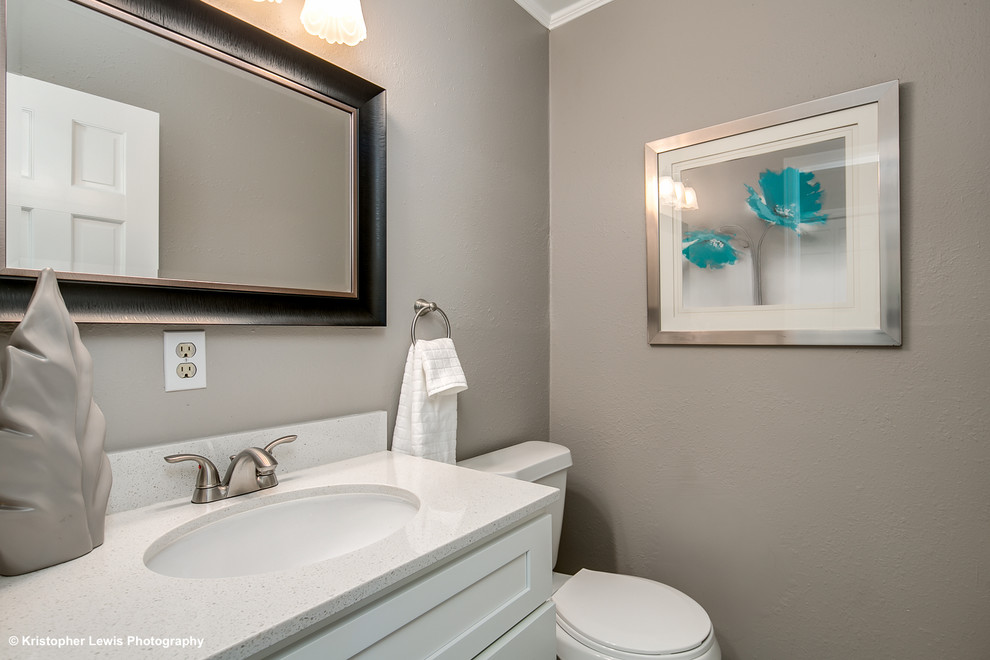 Photo of a small transitional powder room in Other with shaker cabinets, white cabinets, a two-piece toilet, grey walls and engineered quartz benchtops.