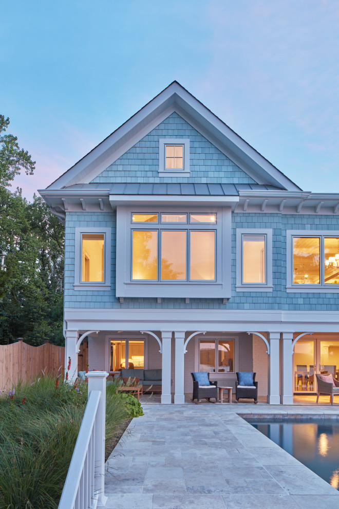 Photo of a beach style blue house exterior in Baltimore with a mixed roof, a grey roof and shingle siding.