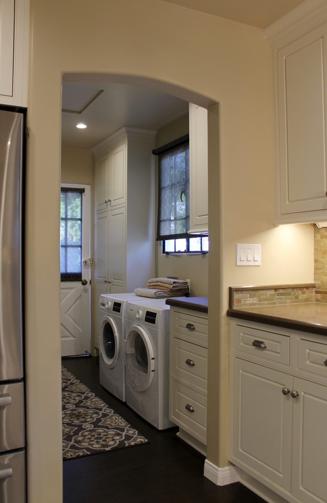 Design ideas for a mid-sized transitional galley dedicated laundry room in Los Angeles with beaded inset cabinets, white cabinets, quartz benchtops, beige walls, cork floors, a side-by-side washer and dryer and brown floor.