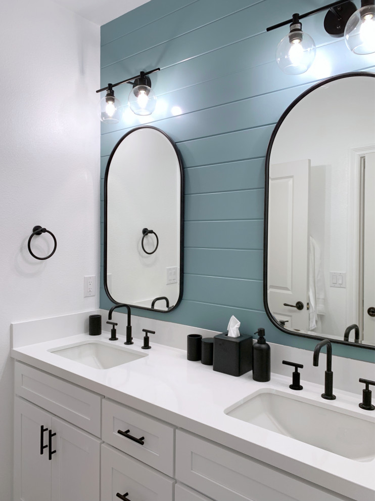 Design ideas for a small contemporary kids bathroom in Orange County with shaker cabinets, white cabinets, a drop-in tub, a shower/bathtub combo, a one-piece toilet, white tile, ceramic tile, blue walls, ceramic floors, an undermount sink, engineered quartz benchtops, multi-coloured floor, a sliding shower screen, white benchtops, a double vanity, a built-in vanity and planked wall panelling.