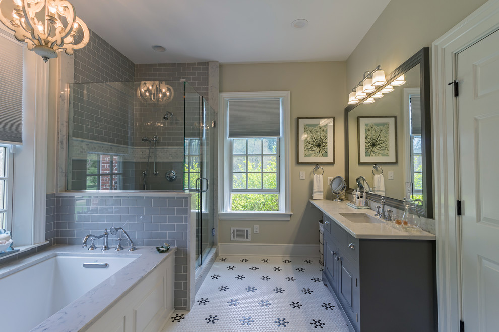 Inspiration for a mid-sized transitional master gray tile and subway tile ceramic tile and white floor corner shower remodel with an undermount tub, a two-piece toilet, an undermount sink, a hinged shower door, raised-panel cabinets, gray cabinets, beige walls and marble countertops