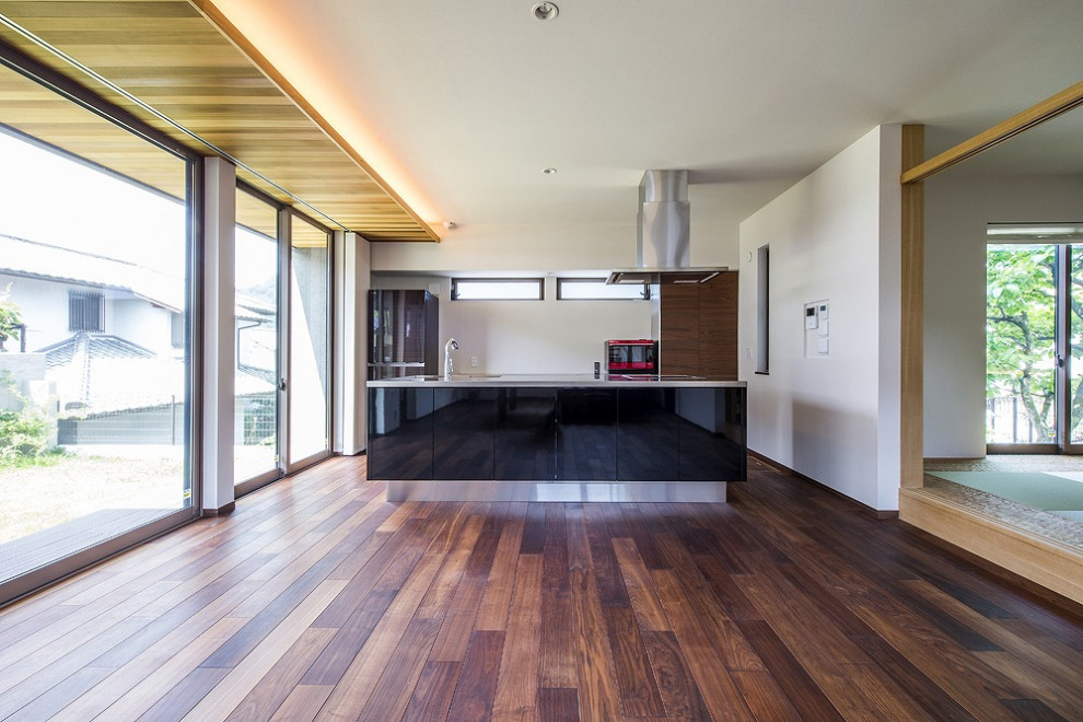 Photo of a modern kitchen in Kobe with dark hardwood flooring, brown floors and black worktops.