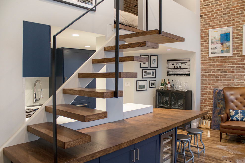 This is an example of a mid-sized modern wood floating staircase in New York with metal railing.