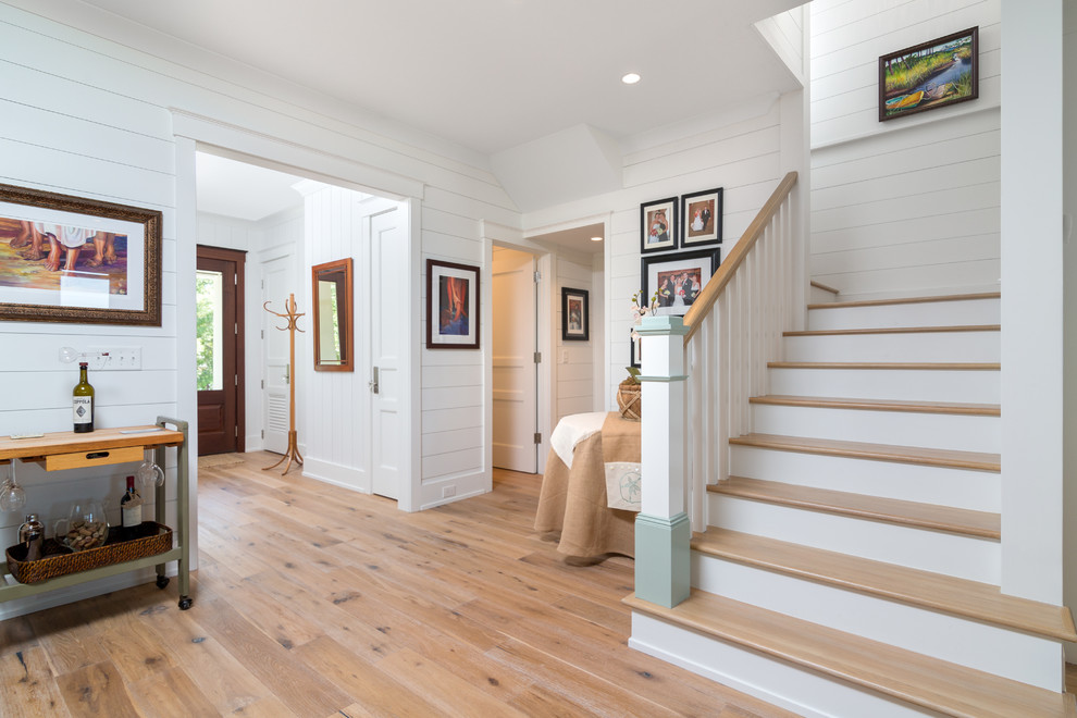 Photo of a mid-sized beach style hallway in Atlanta with white walls and medium hardwood floors.