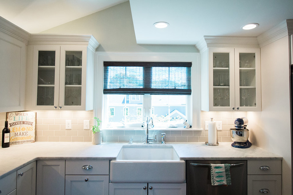 Mid-sized transitional l-shaped dark wood floor and brown floor eat-in kitchen photo in Boston with a farmhouse sink, shaker cabinets, white cabinets, marble countertops, gray backsplash, subway tile backsplash, stainless steel appliances and an island