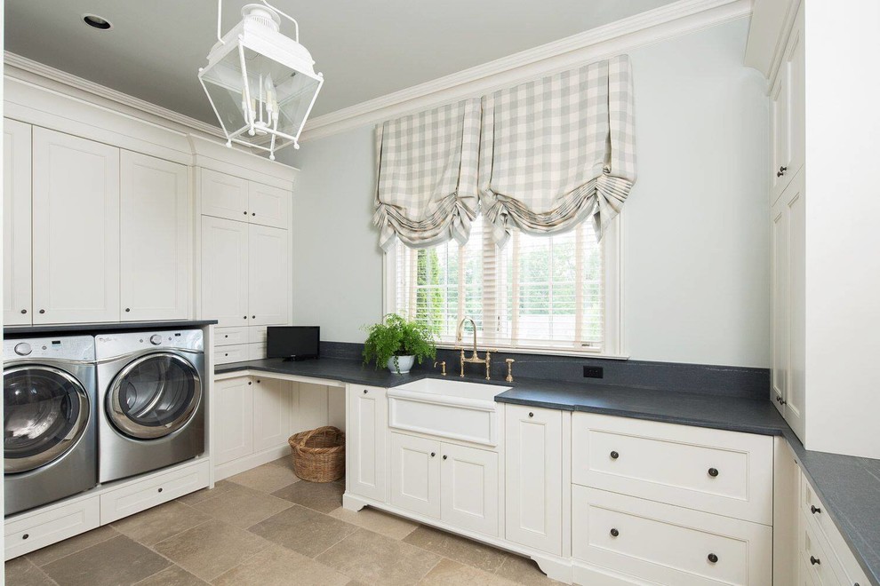 Traditional u-shaped dedicated laundry room in Other with a farmhouse sink, recessed-panel cabinets, white cabinets, a side-by-side washer and dryer and beige floor.