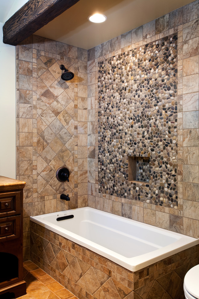 This is an example of an expansive traditional bathroom in Los Angeles with an undermount sink, furniture-like cabinets, medium wood cabinets, marble benchtops, a drop-in tub, brown tile, stone tile and medium hardwood floors.