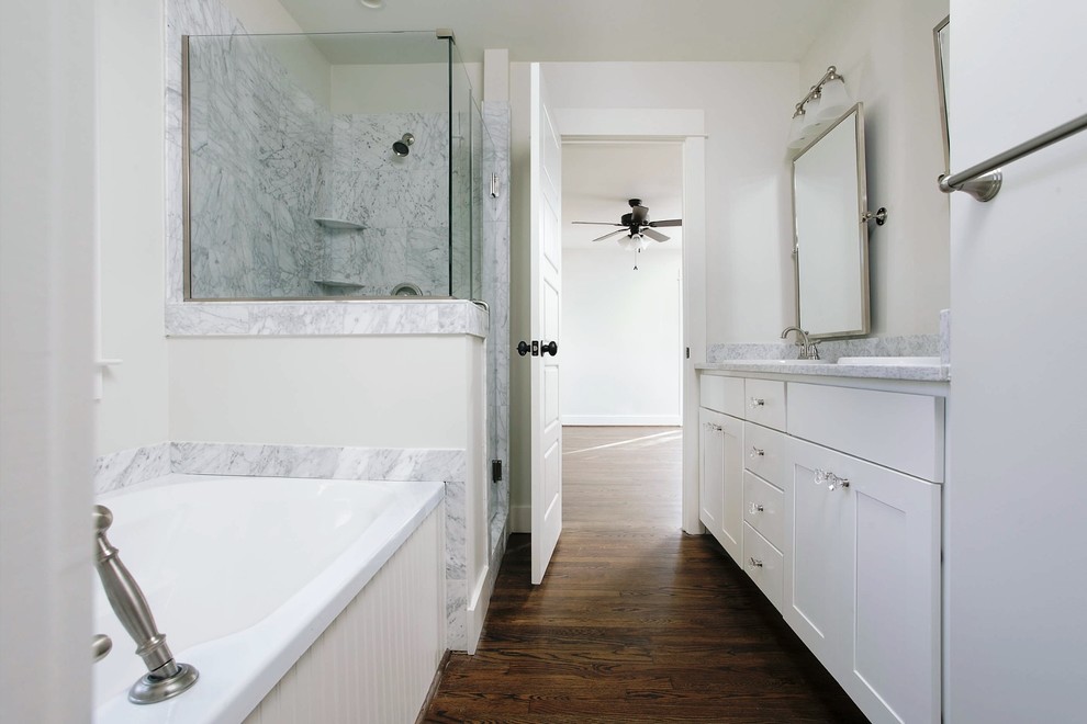 Small traditional master bathroom in Birmingham with a drop-in sink, shaker cabinets, white cabinets, granite benchtops, a drop-in tub, an open shower, a one-piece toilet, white tile, white walls and medium hardwood floors.