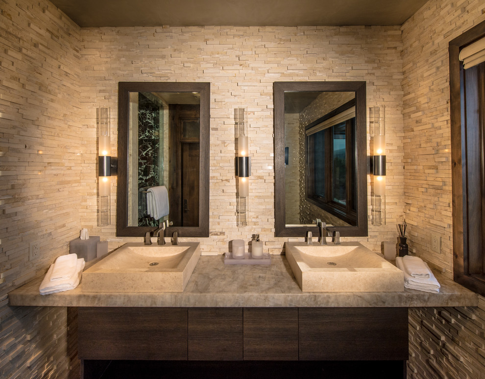 This is an example of a mid-sized country master bathroom in Denver with a vessel sink, flat-panel cabinets, dark wood cabinets, stone tile, beige walls and granite benchtops.