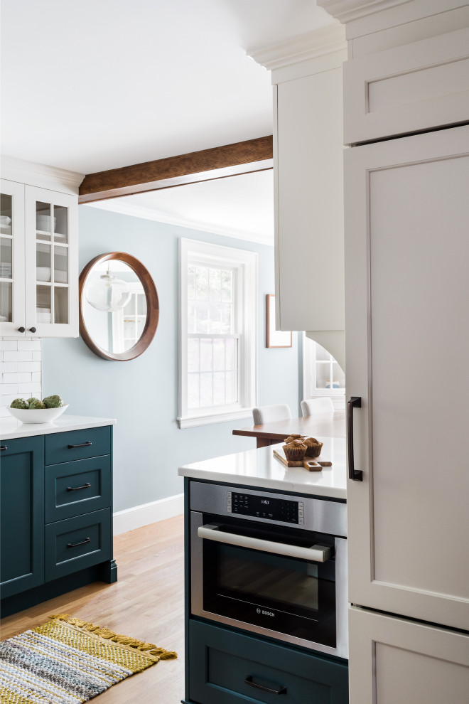 Foto på ett mellanstort lantligt blå kök, med skåp i shakerstil, blå skåp, bänkskiva i kvarts, en rustik diskho, vitt stänkskydd, stänkskydd i tunnelbanekakel, rostfria vitvaror, mellanmörkt trägolv och brunt golv