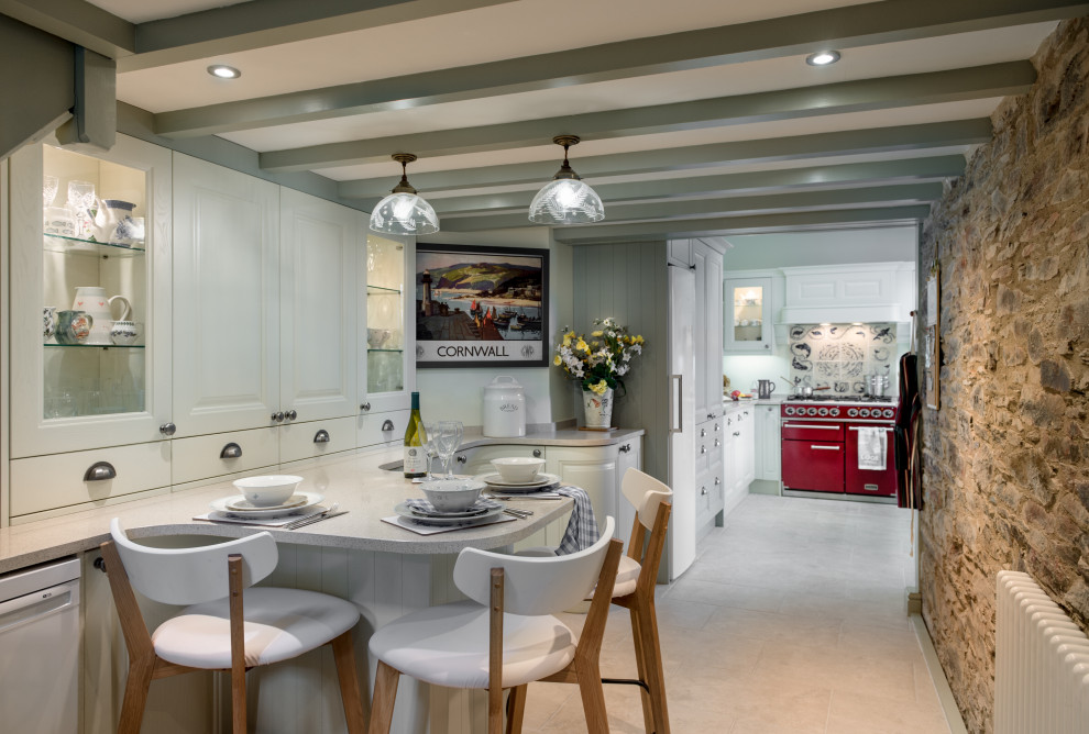 Mid-sized galley open plan kitchen in Cornwall with a drop-in sink, shaker cabinets, green cabinets, quartzite benchtops, blue splashback, ceramic splashback, coloured appliances, cement tiles, with island, beige floor and beige benchtop.