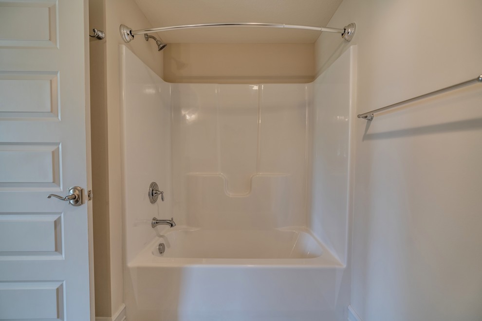 Large transitional kids' beige tile and ceramic tile ceramic tile and brown floor tub/shower combo photo with flat-panel cabinets, brown cabinets, a two-piece toilet, beige walls, an undermount sink, marble countertops, a hinged shower door and beige countertops