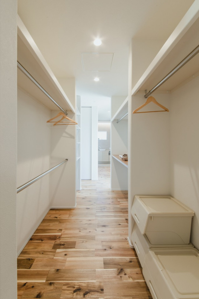 На фото: шкаф в нише в современном стиле с паркетным полом среднего тона, бежевым полом и потолком с обоями