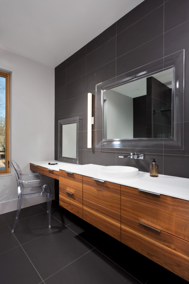 Photo of a large modern master bathroom in New York with flat-panel cabinets, medium wood cabinets, gray tile, porcelain tile, white walls, porcelain floors, solid surface benchtops, grey floor, white benchtops, a niche, a single vanity and a floating vanity.