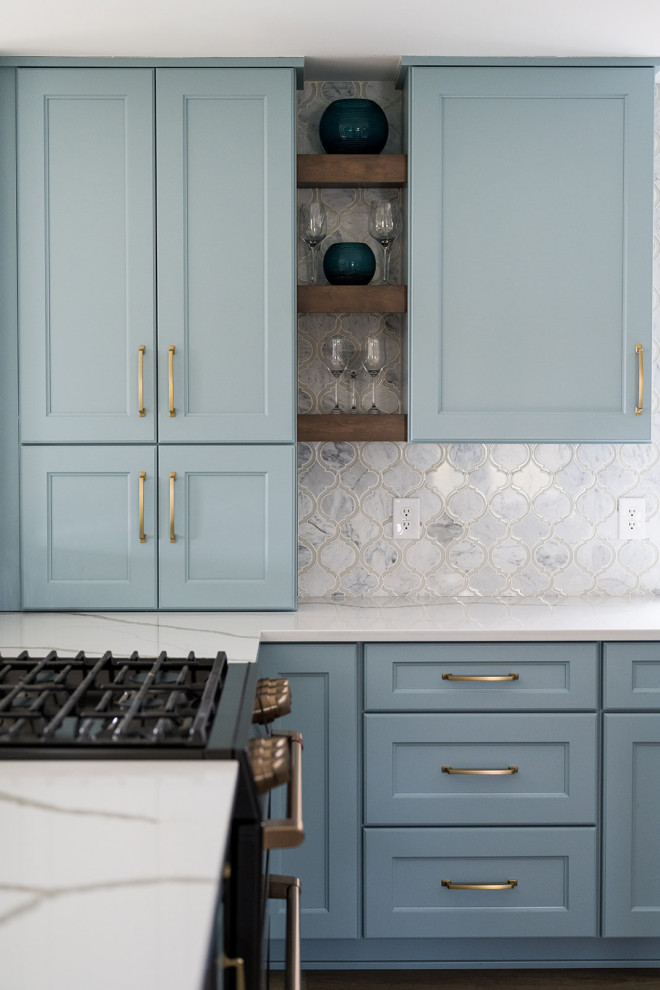 Bild på ett mellanstort funkis vit vitt kök och matrum, med en undermonterad diskho, skåp i shakerstil, blå skåp, bänkskiva i kvarts, rostfria vitvaror, mellanmörkt trägolv och en köksö