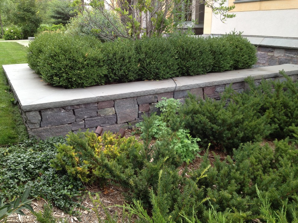 Inspiration for a mid-sized traditional courtyard garden in Minneapolis with a retaining wall.