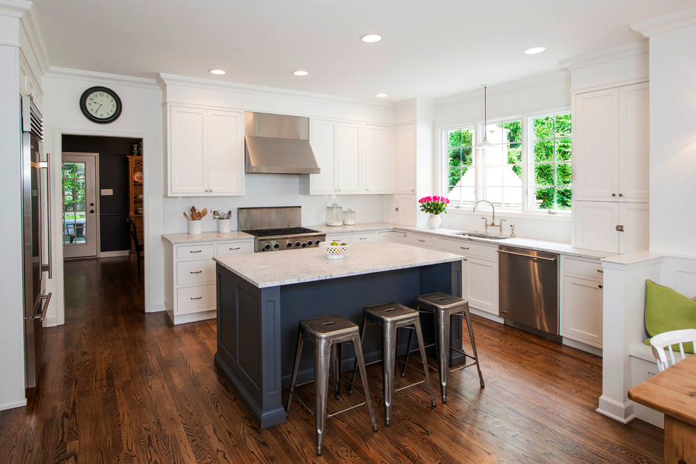 Inspiration for a traditional l-shaped kitchen in Baltimore with stainless steel appliances, an undermount sink, white cabinets, white splashback, subway tile splashback and shaker cabinets.