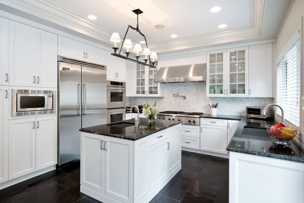 Design ideas for a transitional u-shaped separate kitchen in Chicago with an undermount sink, recessed-panel cabinets, white cabinets, white splashback, stone tile splashback, stainless steel appliances, granite benchtops, limestone floors and with island.
