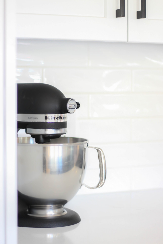Kitchen - transitional beige floor kitchen idea with white backsplash, subway tile backsplash, white countertops, shaker cabinets, white cabinets and quartz countertops