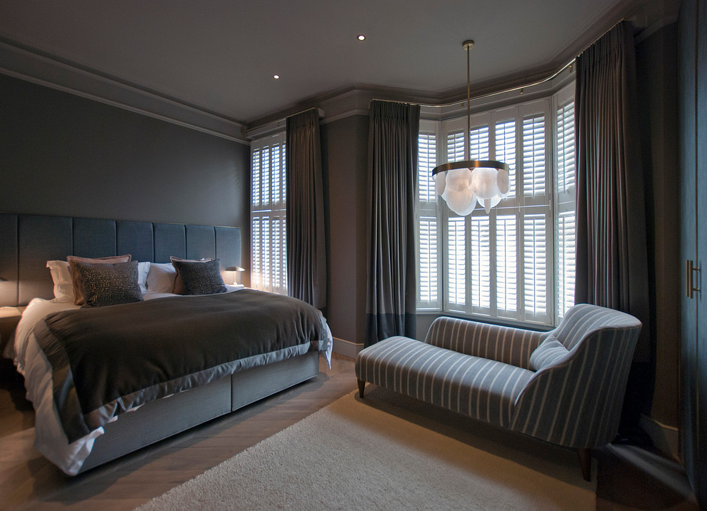 Photo of a contemporary master bedroom in London with grey walls, light hardwood floors and grey floor.