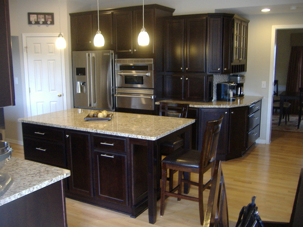 Inspiration for a transitional u-shaped eat-in kitchen remodel in Indianapolis with an undermount sink, flat-panel cabinets, dark wood cabinets, granite countertops and stainless steel appliances