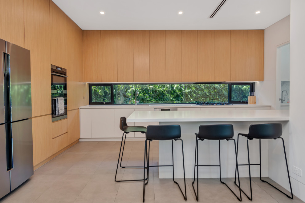 Trendy galley kitchen photo in Sydney with an undermount sink, flat-panel cabinets, light wood cabinets, quartz countertops and white countertops