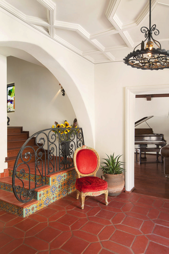 This is an example of a mediterranean foyer in Los Angeles with terra-cotta floors and red floor.