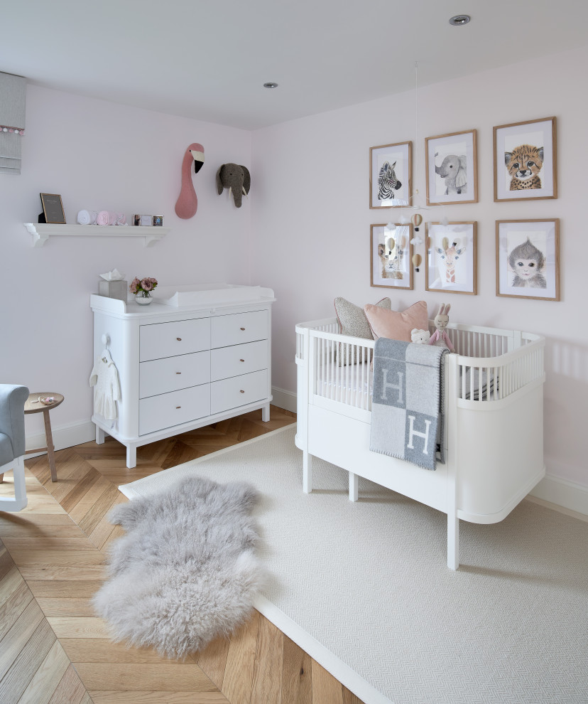 Inspiration for a medium sized contemporary nursery for girls in Other with pink walls, medium hardwood flooring and wallpapered walls.