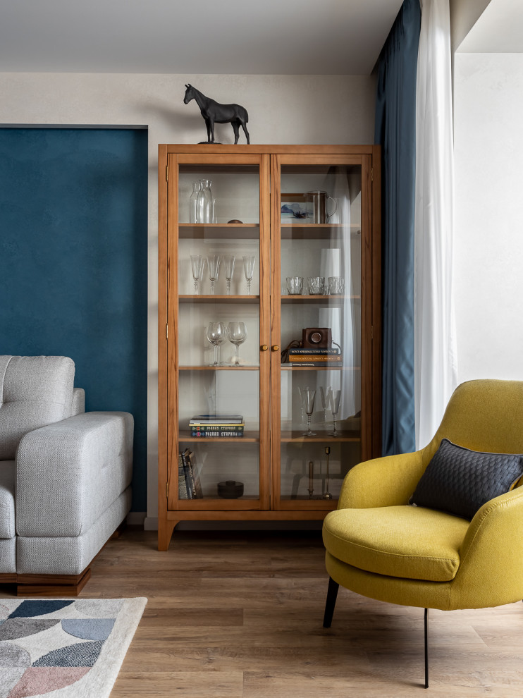 На фото: открытая, серо-белая гостиная комната среднего размера в современном стиле с синими стенами, светлым паркетным полом, телевизором на стене, коричневым полом и акцентной стеной с