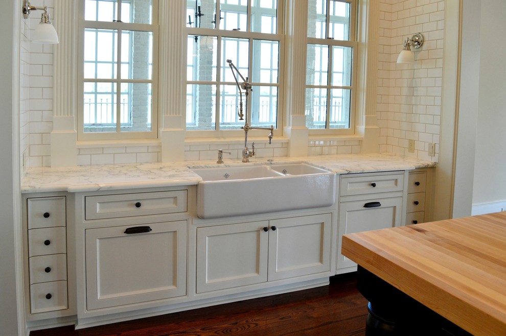 Photo of a large transitional u-shaped eat-in kitchen in Houston with a farmhouse sink, flat-panel cabinets, white cabinets, white splashback, panelled appliances and dark hardwood floors.
