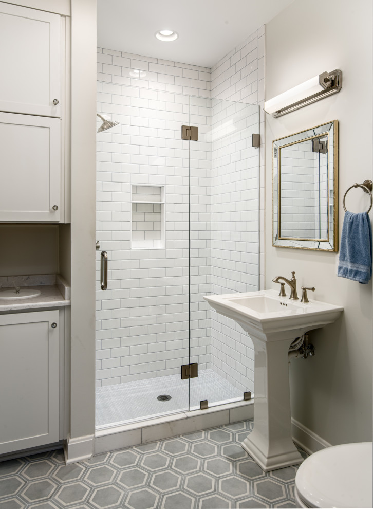 This is an example of a small traditional bathroom in Nashville with white cabinets, an alcove shower, a one-piece toilet, white tiles, porcelain tiles, grey walls, porcelain flooring, a pedestal sink, a hinged door, a single sink and a freestanding vanity unit.
