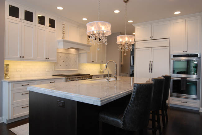 Inspiration for a mid-sized transitional l-shaped dark wood floor open concept kitchen remodel in Chicago with an undermount sink, shaker cabinets, white cabinets, marble countertops, white backsplash, stone tile backsplash, stainless steel appliances and an island