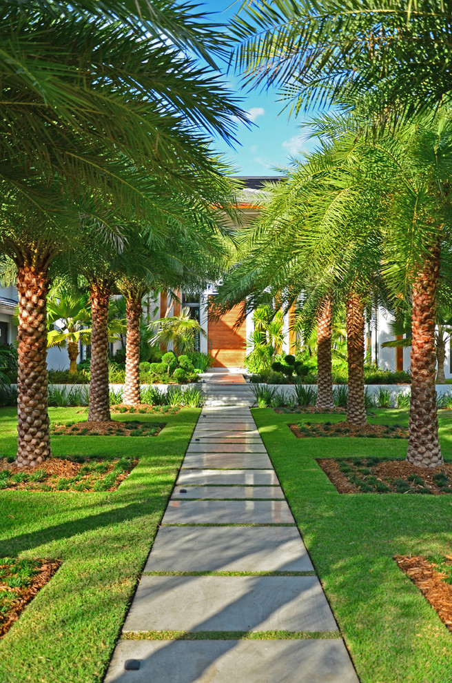 Inspiration for a large asian front yard full sun driveway in Miami with natural stone pavers.