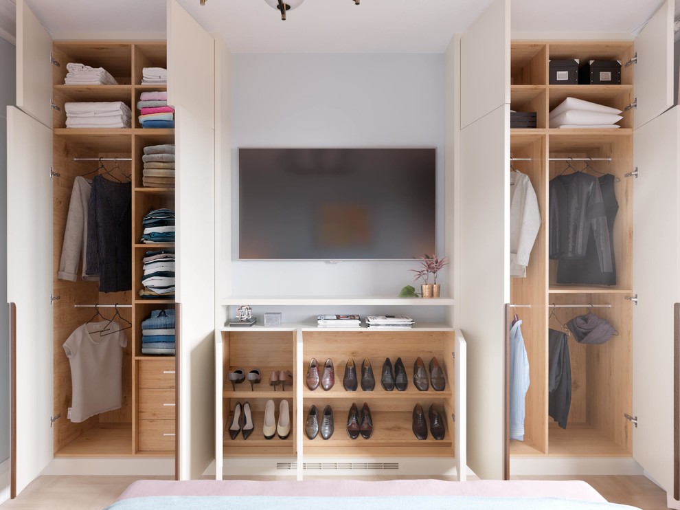 This is an example of a mid-sized contemporary gender-neutral built-in wardrobe in London with flat-panel cabinets, white cabinets and beige floor.