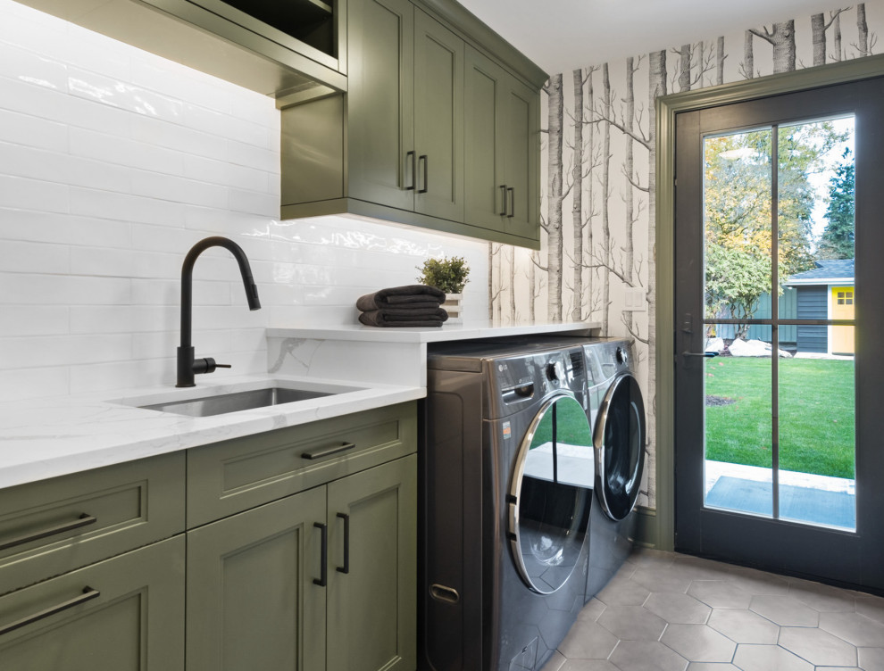 Photo of a mid-sized country single-wall utility room in Seattle with an undermount sink, beaded inset cabinets, green cabinets, quartz benchtops, white splashback, ceramic splashback, white walls, porcelain floors, a side-by-side washer and dryer, grey floor, white benchtop and wallpaper.