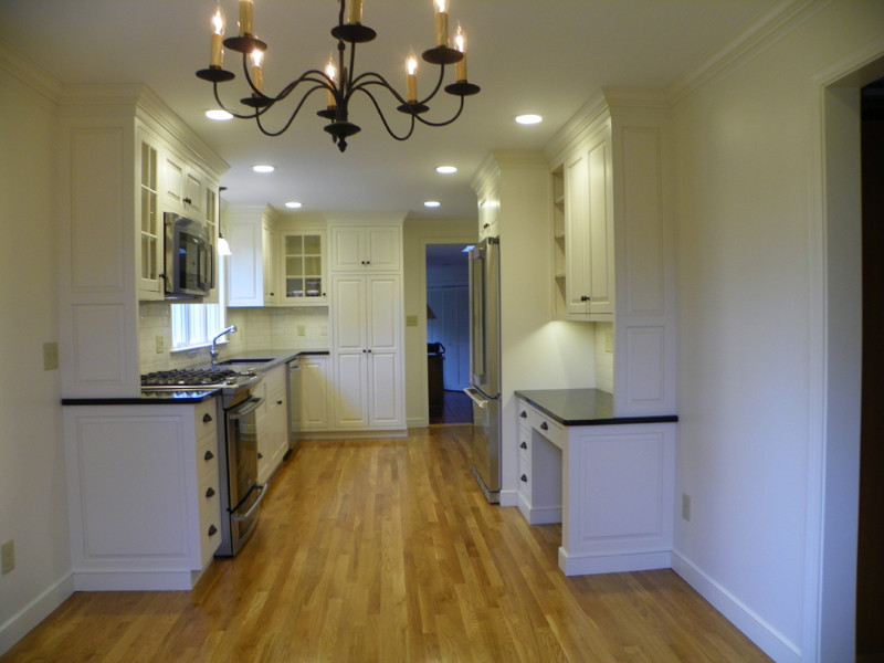 Eat-in kitchen - mid-sized transitional u-shaped light wood floor eat-in kitchen idea in Boston with an undermount sink, beaded inset cabinets, white cabinets, quartz countertops, white backsplash, subway tile backsplash, stainless steel appliances and no island