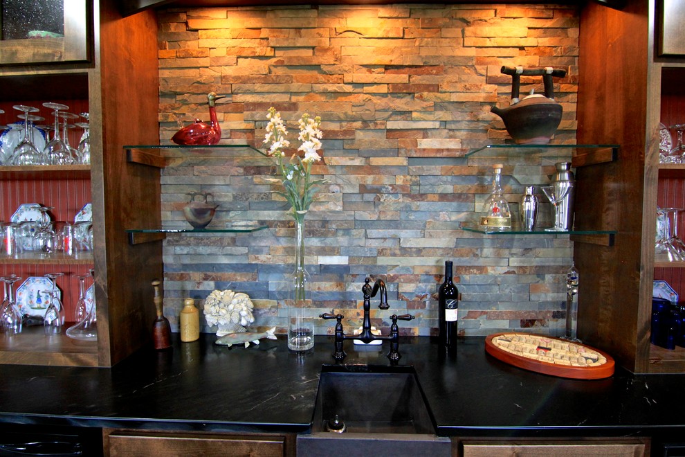 Inspiration for a mid-sized transitional seated home bar in Minneapolis with an undermount sink, shaker cabinets, dark wood cabinets, multi-coloured splashback, slate splashback, slate floors and brown floor.