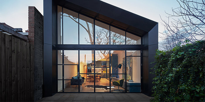 Photo of a mid-sized contemporary one-storey black house exterior in Melbourne with metal siding, a gable roof and a metal roof.