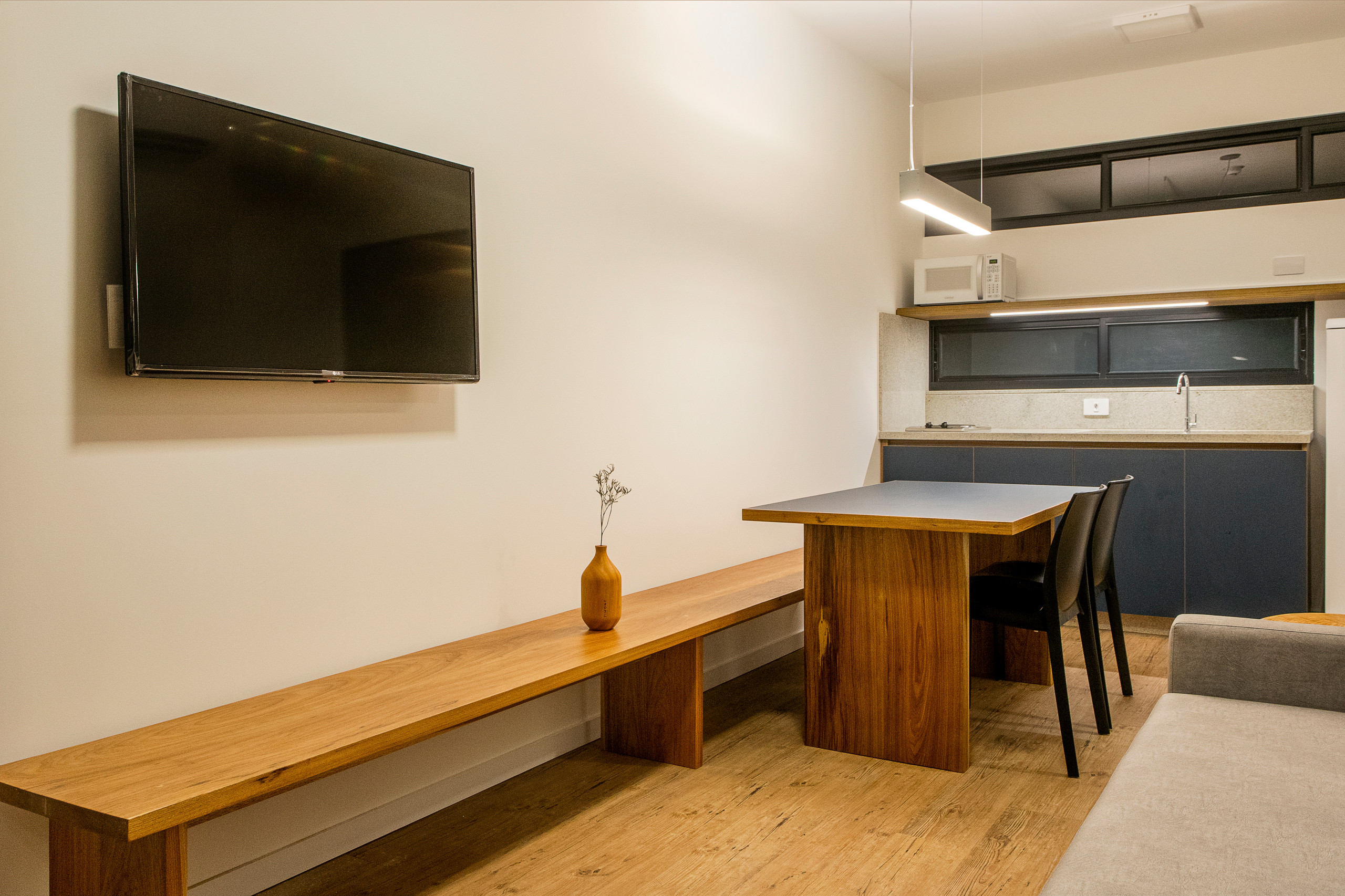 Sala y cocina integradas con banco repisa multiusos.