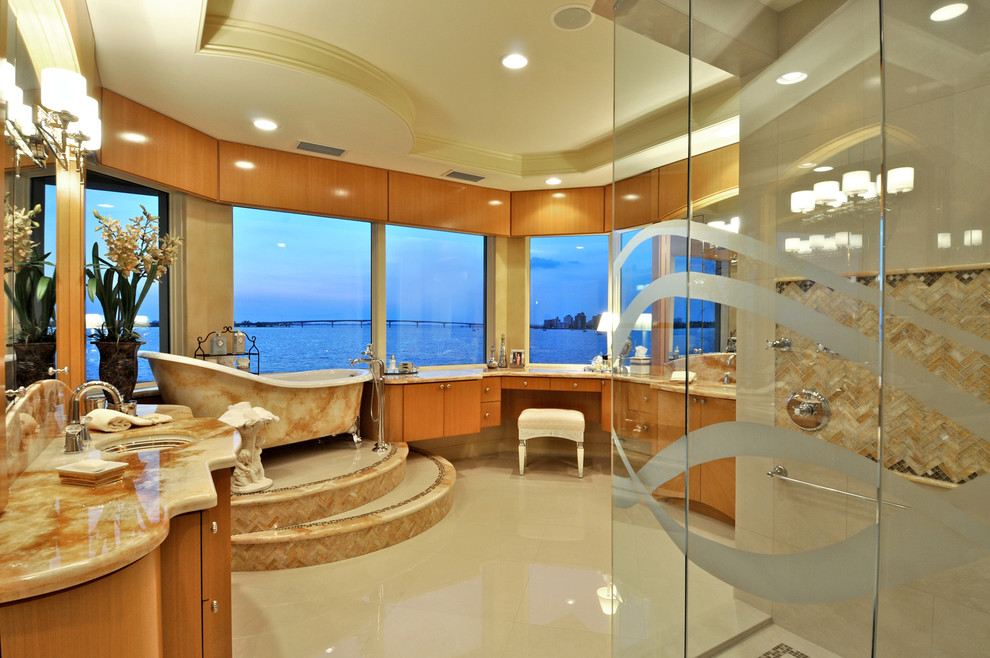 This is an example of an expansive contemporary master bathroom in Tampa with an undermount sink, flat-panel cabinets, medium wood cabinets, granite benchtops, a claw-foot tub, a corner shower, beige tile, matchstick tile and marble floors.
