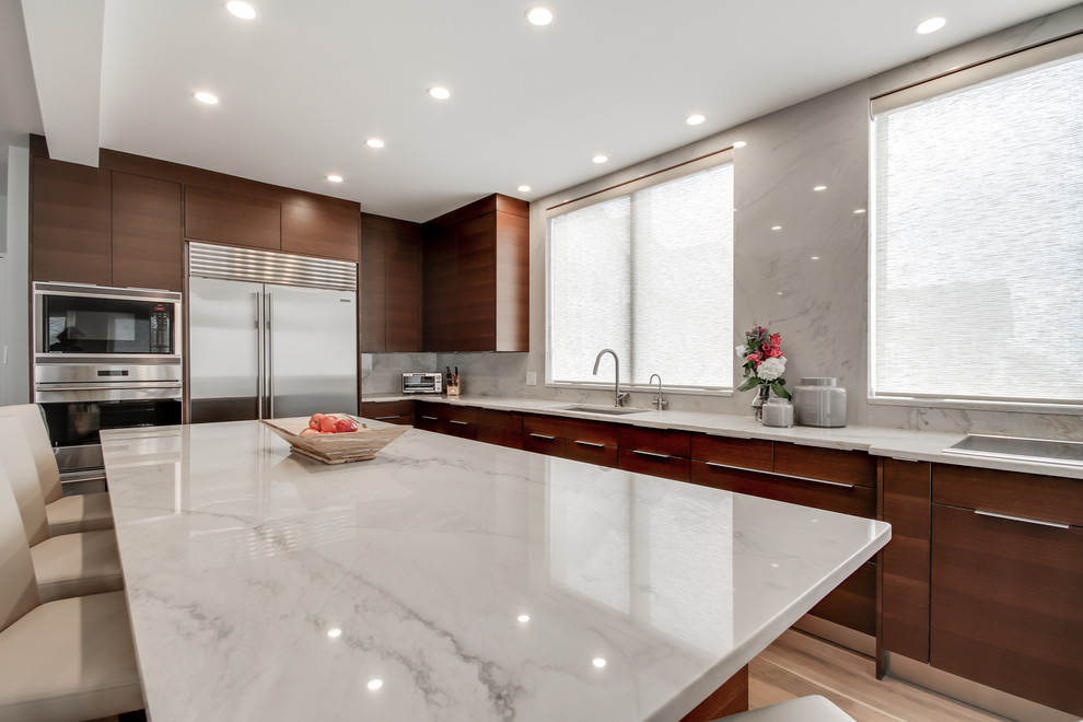 Inspiration for a large contemporary u-shaped eat-in kitchen in Philadelphia with an undermount sink, flat-panel cabinets, dark wood cabinets, quartzite benchtops, white splashback, stone slab splashback, stainless steel appliances, light hardwood floors and with island.
