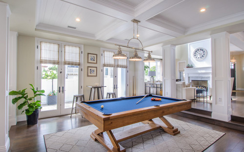 Modern game room with a modern billiard table with a metal pub table and two stools