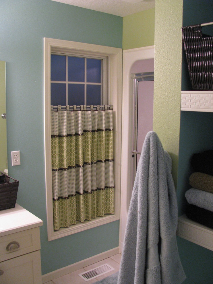 Example of a transitional ceramic tile and beige floor alcove shower design with shaker cabinets, white cabinets and blue walls